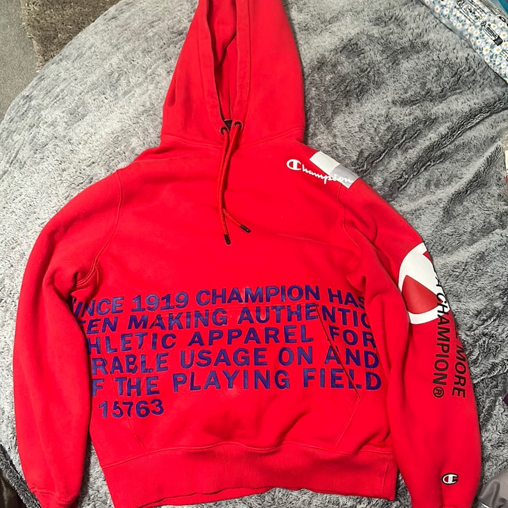Red champion hoodie with print.